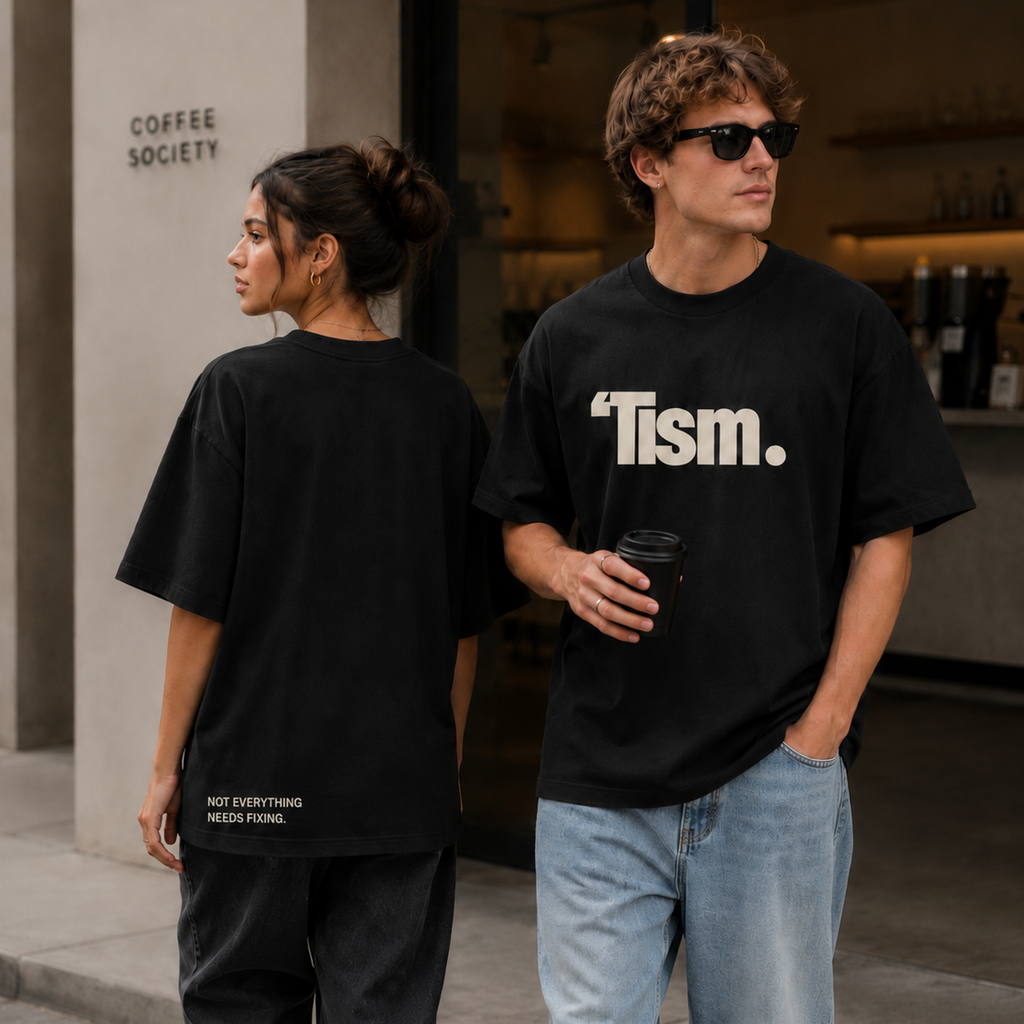 Two people wearing black t-shirts with text, one holding a coffee cup, standing outside a building.